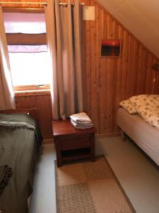 a bedroom with a bed and a table and a window at Kjelkebakken Gard in Lyngseidet +15 photos