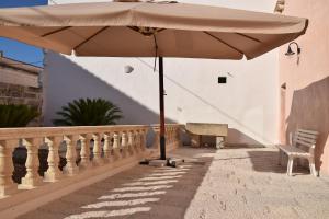 an umbrella on a balcony with a bench at Le Tenute di Agnese in Felline