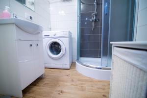 uma casa de banho com uma máquina de lavar roupa e um chuveiro em Apartament pracowniczy em Stalowa Wola