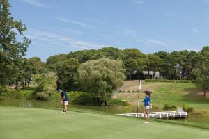 dwie osoby grające w golfa na polu golfowym w obiekcie Blue Rock Resort w mieście South Yarmouth