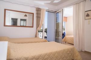 アリンダにあるHotel Elenaのベッド2台と窓が備わるホテルルームです。