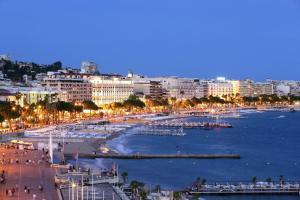 a view of a city with a beach at night at Bright Loft in Cannes