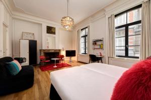 a bedroom with a white bed and a fireplace at Vintage Hotel Brussels in Brussels