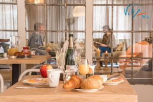 a table with plates of food and bottles of champagne at Villami in Anzegem