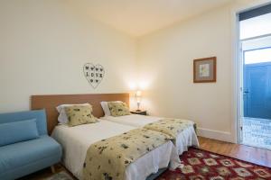 1 dormitorio con 1 cama y 1 silla azul en À Francos Artist Painting, en Oporto