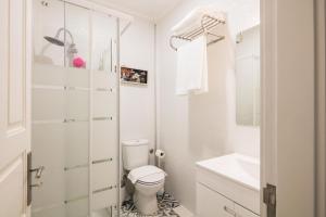 bagno bianco con servizi igienici e lavandino di À Francos Love Lair a Porto