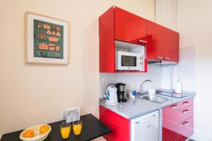a small kitchen with red cabinets and a sink at À Francos Love Lair in Porto