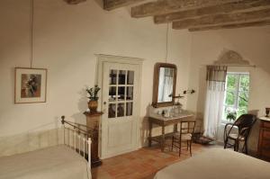 Schlafzimmer mit einem Bett, einem Schreibtisch und einem Spiegel in der Unterkunft Le Relais de Roquefereau in Penne-dʼAgenais