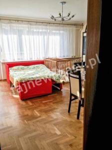 ウストカにあるGrunwaldzka 47のリビングルーム(赤いベッド1台、テーブル付)