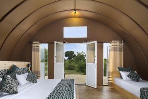 a room with two beds and an open doorway at Leopard Nest - Glamping in Yala in Yala +37 photos