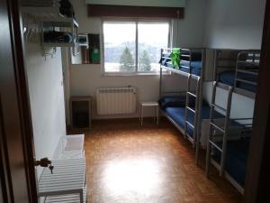 a room with three bunk beds and a window at Casa Do Marabillas in Portomarin