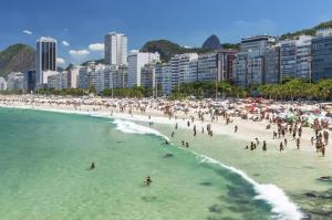 un grupo de personas en una playa en el agua en Apto. Confortável em Copacabana, en Río de Janeiro