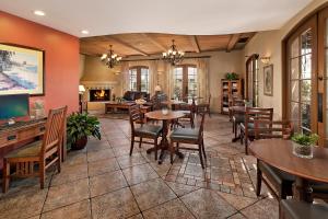 a living room with tables and chairs and a fireplace at Brisas Del Mar Inn at the Beach in Santa Barbara