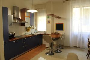 cocina con mesa de madera y encimera en Carbonara Apartment en Bolonia