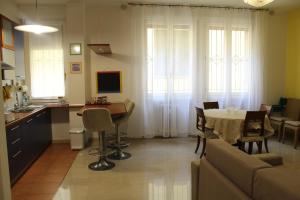 Carbonara Apartment في بولونيا: مطبخ وغرفة معيشة مع طاولة وأريكة