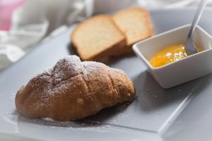 a plate of bread and a bowl of orange dipping sauce at Anna Guest House in Rome