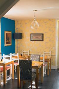een eetkamer met houten tafels en stoelen bij La Petite Auberge in Carennac
