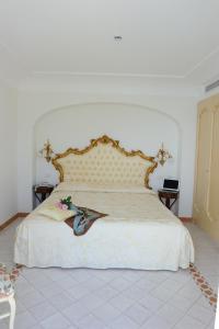 a bedroom with a large bed with a large headboard at Hotel Villa Fraulo in Ravello