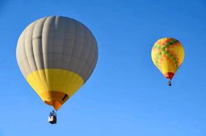 two hot air balloons flying in the sky at Monte dos Aroeirais in Fronteira
