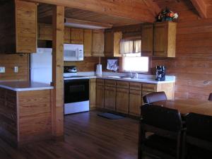 a kitchen with white appliances and a table in a cabin at Mill Creek Resort on Table Rock Lake in Lampe +38 photos