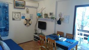 uma sala de jantar com uma mesa azul e uma televisão em Holiday Home Bah em Kruševo