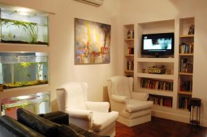 a living room with a couch and chairs and a fish tank at Bohemia Hotel Boutique in Mendoza