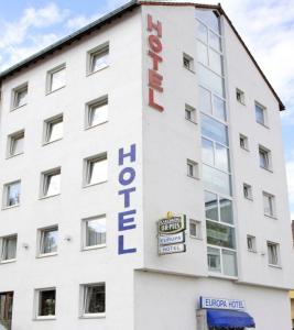 - un bâtiment blanc avec un panneau indiquant l'hôtel dans l'établissement Europa Hotel City, à Sarrebruck