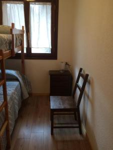 a room with a chair and a bed and a window at Apartamento Santa Marina in Tramacastilla de Tena +2 photos