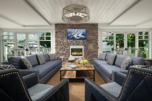 a living room with blue couches and a fireplace at Hyannis Harbor Hotel in Hyannis