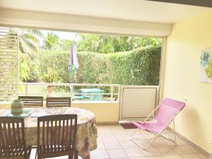 a patio with a table and chairs and a window at Maxi cosy appartement in Sainte-Anne