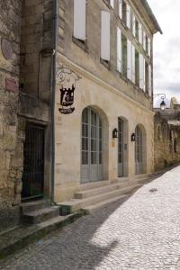 un edificio de piedra en una calle adoquinada en Auberge de la Commanderie en Saint-Émilion