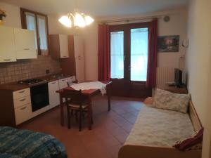 eine Küche und ein Wohnzimmer mit einem Tisch und einem Sofa in der Unterkunft Appartamento BeB Preone CIR17089BEB01 in Limone sul Garda