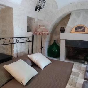 1 dormitorio con 1 cama con lámpara y chimenea en Trulli Villa Gloria, en Alberobello