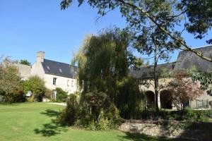 a large white house with a tree in the yard at Le Manoir des Doyens in Bayeux