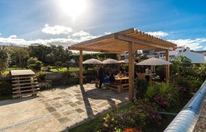 a pavilion with tables and umbrellas in a garden at Out of the Blue in Ponta Delgada