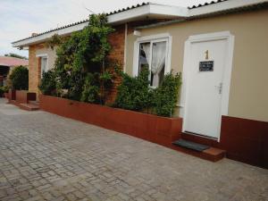 a house with a white door and some plants at Villelodge Accommodation in L&uuml;deritz