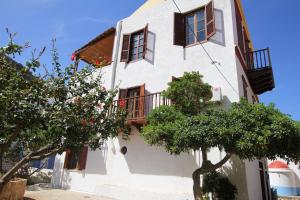 a white building with windows and a balcony at Traditional Apartments Alexandra in Meyisti