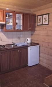 a kitchen with a sink and a white refrigerator at Pokoje gościnne u Danuty in Mizerna