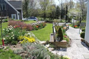a garden with flowers in a yard next to a house at Lavender Bay in Barnstable +12 photos