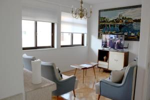 - un salon avec des chaises, une table et une télévision dans l'établissement Family Espinho Porto Guesthouse, à Espinho