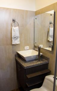 uma casa de banho com um lavatório, um espelho e um WC. em HYG Hotel em Pasto