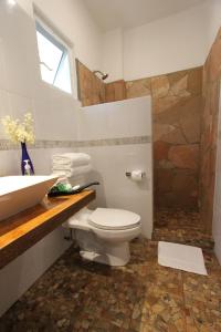 bagno con servizi igienici e lavandino di Hotel Villa Mozart y Macondo a Puerto Escondido