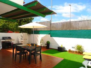 a patio with a table and chairs and an umbrella at bungalow Las TARTANAS I I in Maspalomas