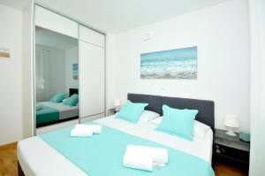 ein Schlafzimmer mit einem großen Bett mit blauen Kissen in der Unterkunft Apartments Town in Trogir