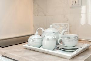 a tray with three cups and plates on a counter at Appartamento Via Acquati 12 - Monolocale 1 in Cormano