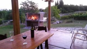 a wooden table with two glasses of wine and a fireplace at Cabaña del Alto Tupungato in Tupungato