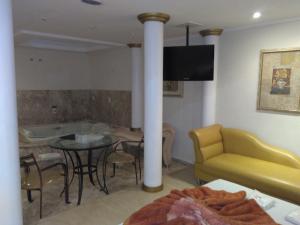 a living room with a table and a yellow couch at Heru's Motel in Poços de Caldas