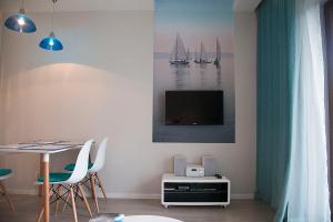 a living room with a table and a tv on a wall at Baltic View Apartment in Dziwnówek