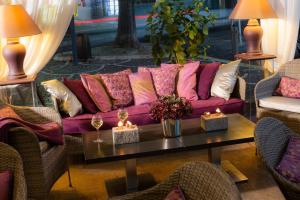 a purple couch in a room with a table with candles at La Place Boutique Hotel in Antibes