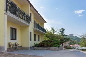 ein gelbes Gebäude mit Stühlen und einem Balkon in der Unterkunft Apartments Marijana in Senj